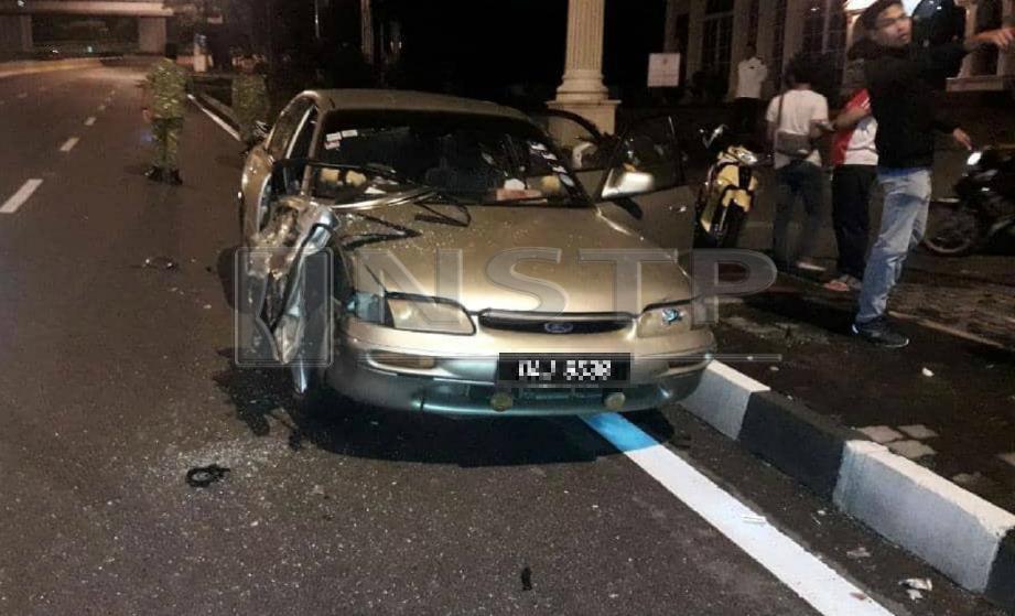 KEADAAN kereta diperiksa Mohd Zamri bersama rakannya sebelum dirempuh kereta lain yang terbabas di tepi Jalan Semantan, Kuala Lumpur, awal pagi hari ini. FOTO ihsan polis.