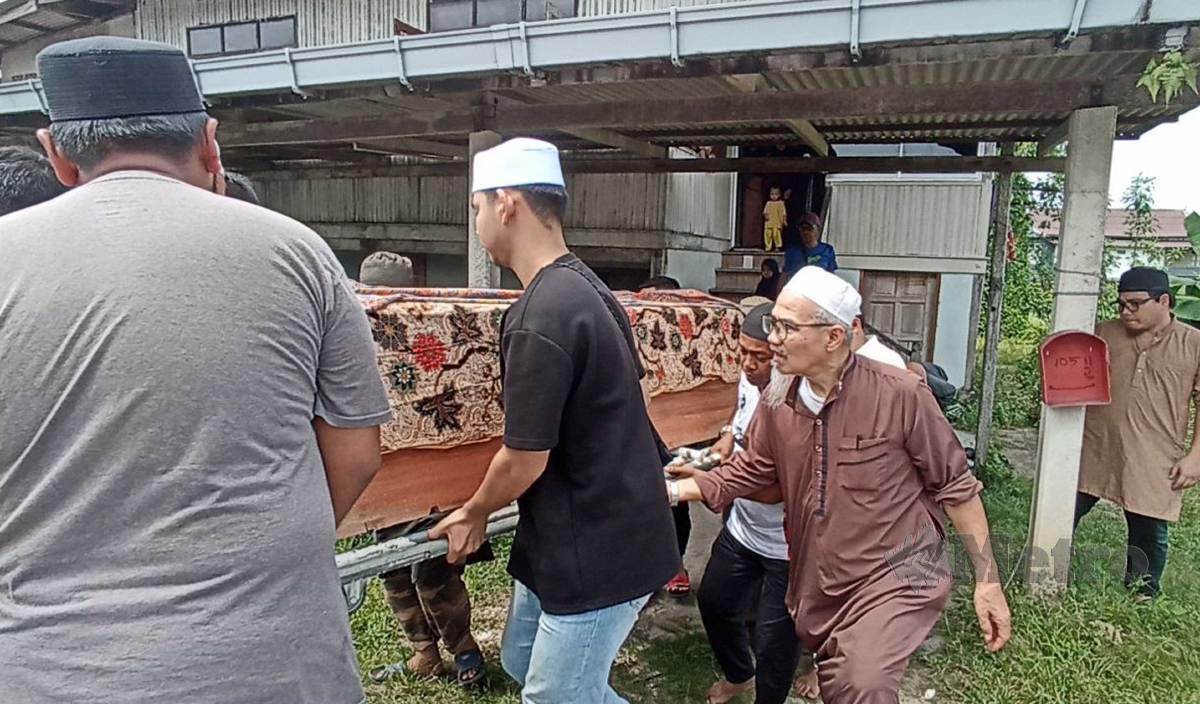 DIN (tiga kanan) mengusung keranda jenazah anaknya, Ahmad Yusuf untuk disembahyangkan Di Masjid Kampung Bukit Tumbuh sebelum di kebumikan di Tanah Perkuburan Islam kampung berkenaan. FOTO Zaid Salim