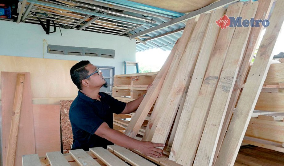 AZIZUL memilih kayu palet yang dibeli dari kilang sekitar Perlis sebelum digunakan untuk menghasilkan perabot di rumahnya. FOTO Dziyaul Afnan Abdul Rahman