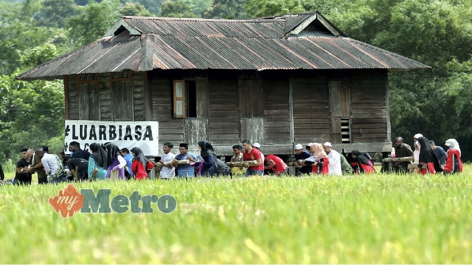PESERTA bergotong-royong mengusung rumah pusaka sejauh 150 meter di Kampung Labu Kubong, Lubuk Merbau, Kuala Kangsar, hari ini. FOTO Effendy Rashid