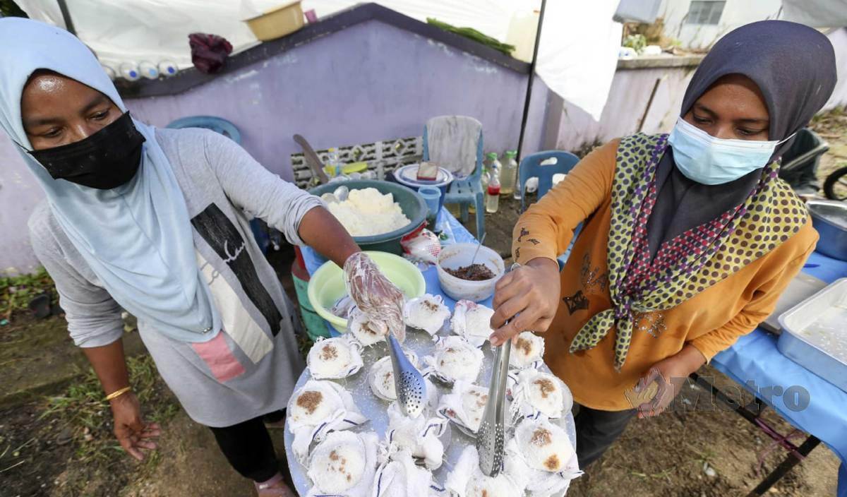 KALSOM (kiri) bersama dengan Nor Asikin menyediakan putu halba yang dijualnya di Kampung Kubang Batang. FOTO Nik Abdullah Nik Omar