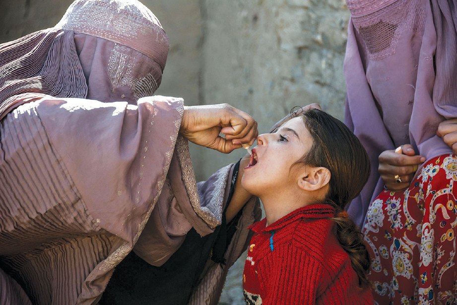 PETUGAS kesihatan Afghanistan memberi vaksin polio kepada kanak-kanak daerah Arghandab dalam wilayah Kandahar. FOTO AFP