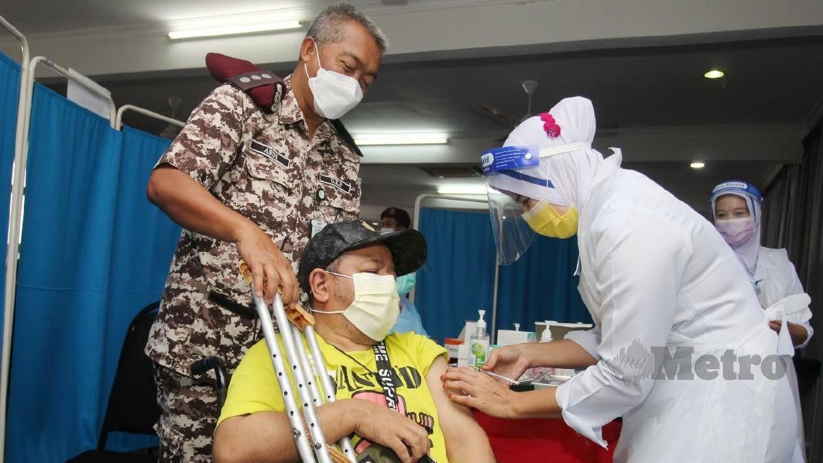 Mohd Faiza menerima suntikan vaksin di PPV sementara di Dewan Tan Sri Murad Ahmad di Penjara Pengkalan Chepa, Kota Bharu semalam. Foto Nik Abdullah Nik Omar 