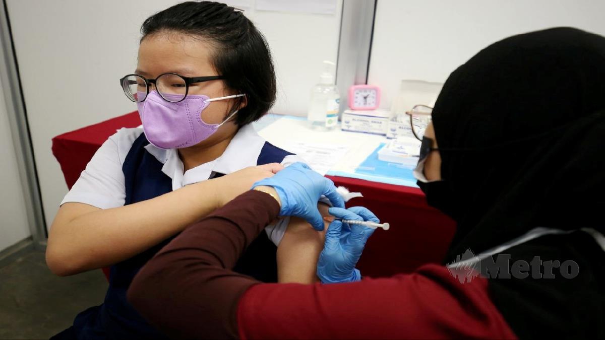 PETUGAS perubatan memberikan suntikan vaksin Covid-19 kepada kanak-kanak di Pusat Pemberian Vaksin Tapak Pesta Sungai Nibong. FOTO MIKAIL ONG