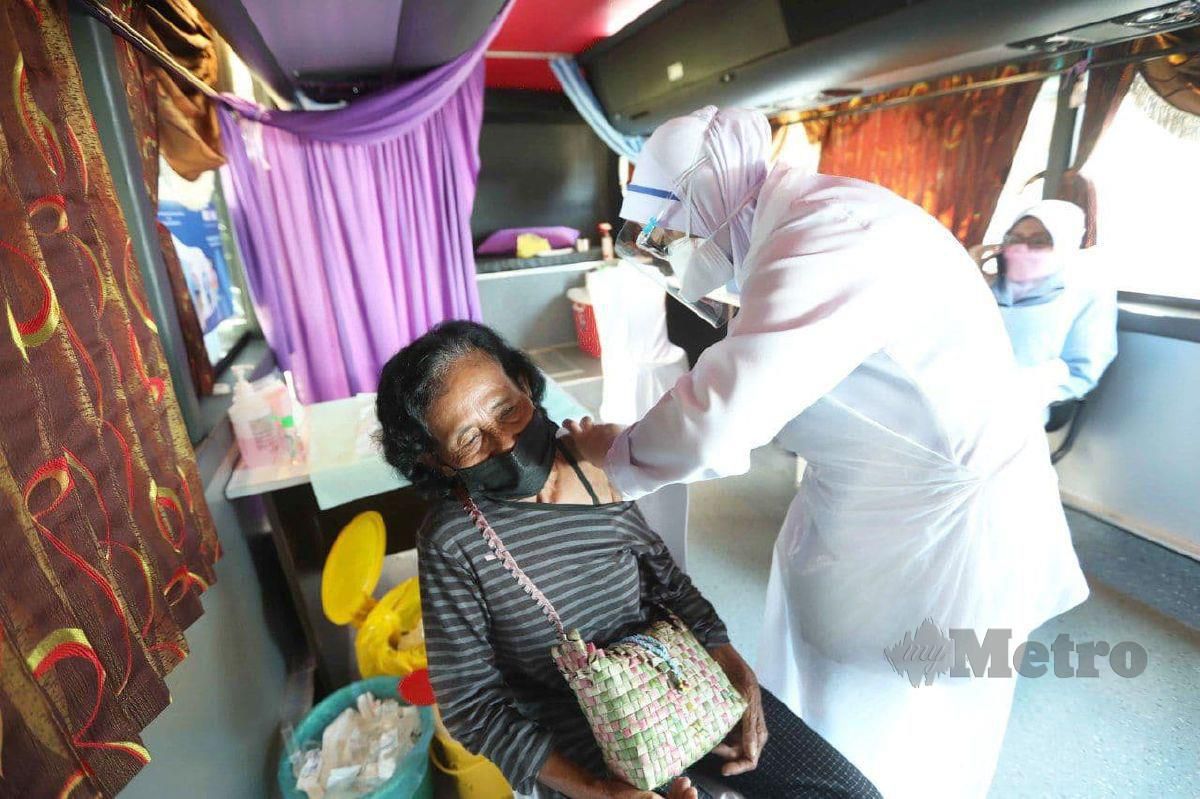 Minah Suri menerima suntikan vaksin Covid-19 pada Program Outreach Mobilisasi Vaksin Komuniti (MOVAK) di Kampung Orang Asli Merbau. FOTO MOHD RAFI MAMAT