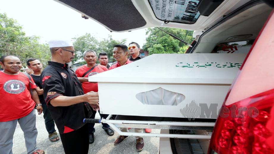 KETUA Bilal jenazah UKVJ, Mohd Yusof Hassan (tiga dari kiri) memeriksa pengusung dalam van jenazah sebelum diserahkan kepada RBKM. FOTO Khairunisah Lokman.