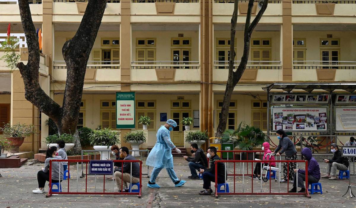 PENDUDUK memakai pelitup muka dan mematuhi penjarakan fizikal ketika menunggu giliran untuk ujian saringan Covid-19 di Hospital Bach Mai, Hanoi. FOTO AFP