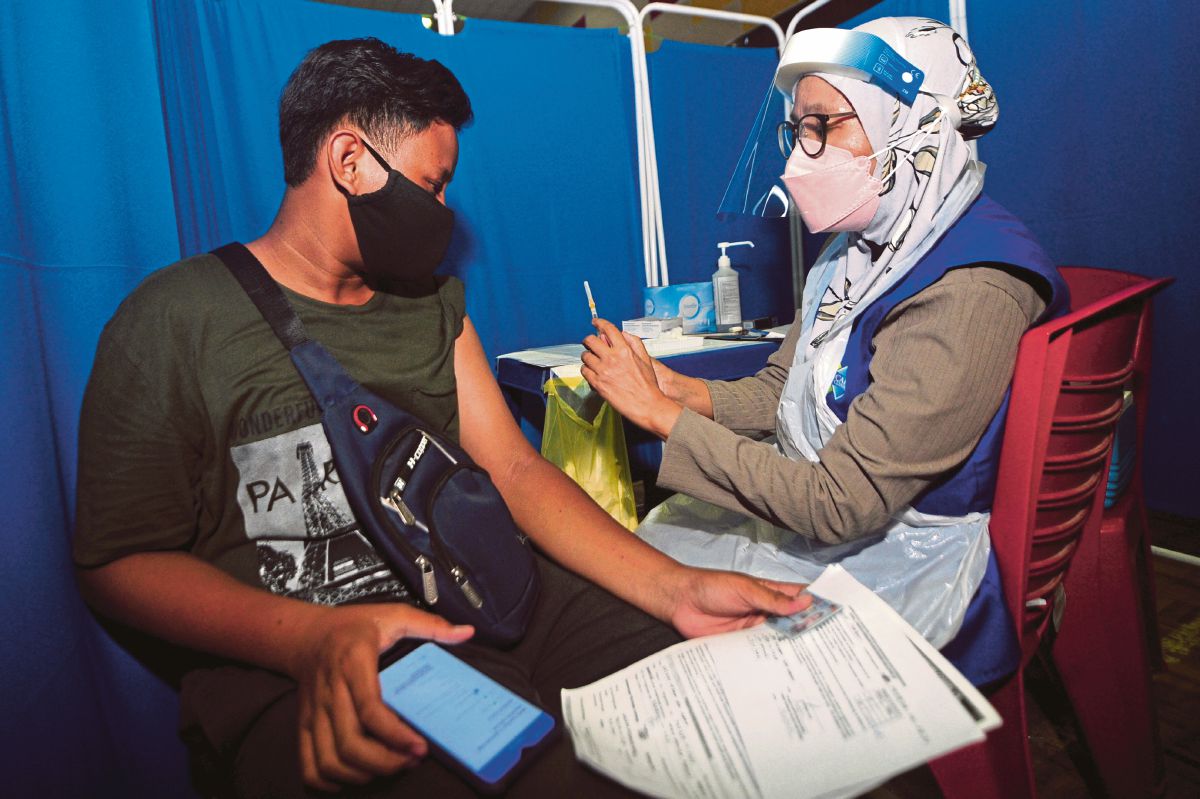 PETUGAS kesihatan memberi suntikan vaksin Covid-19 kepada pelajar sekolah di Pusat Pemberian Vaksin (PPV) Sekolah Menengah Kebangsaan Agama (SMKA) Kuala Selangor, semalam. FOTO BERNAMA 