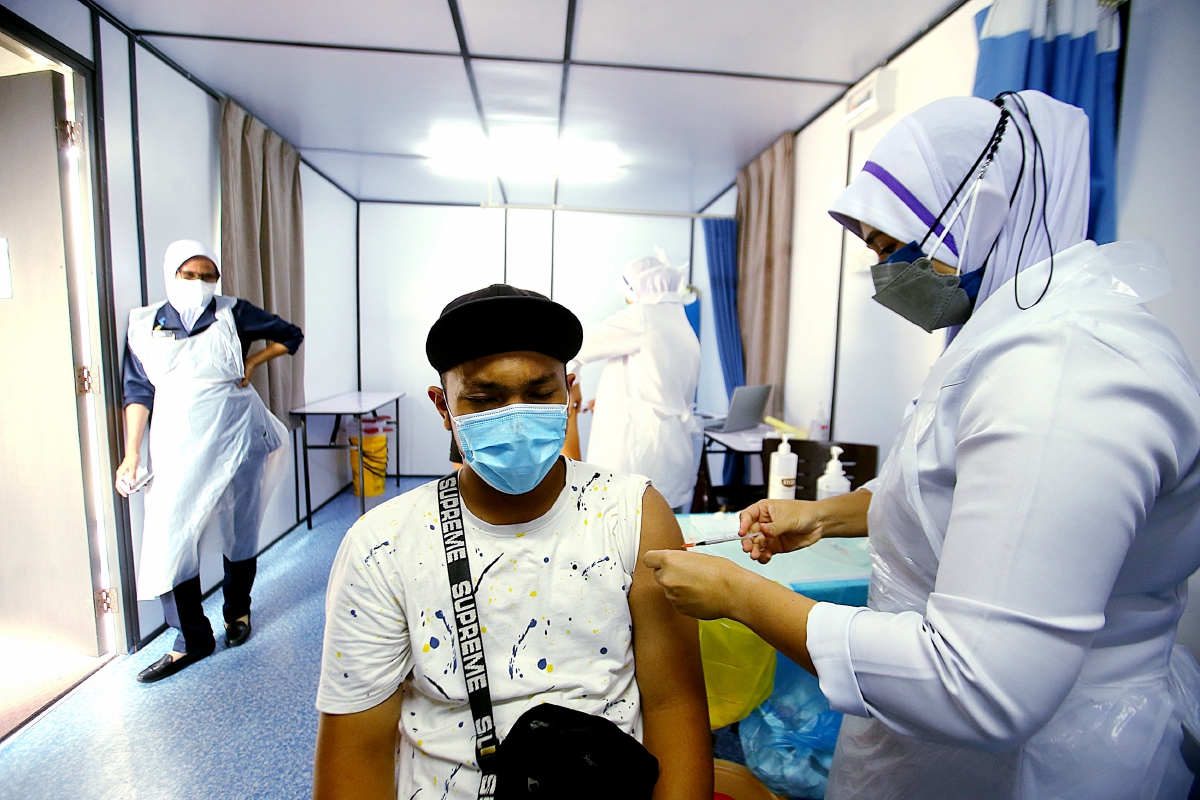 ORANG ramai menerima suntikan vaksin yang dikendali petugas kesihatan di Klinik Kesihatan Sungai Bertek, Klang. FOTO Faiz Anuar  