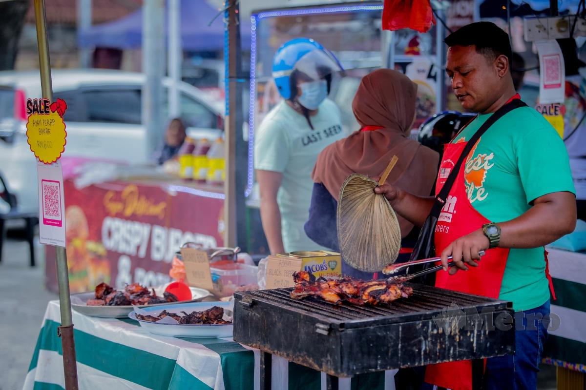 Saiful Anuar membakar ayam untuk dijual pada harga RM8 ketika tinjauan harga makanan di Bazar Ramadan Keramat. FOTO ASYRAF HAMZAH