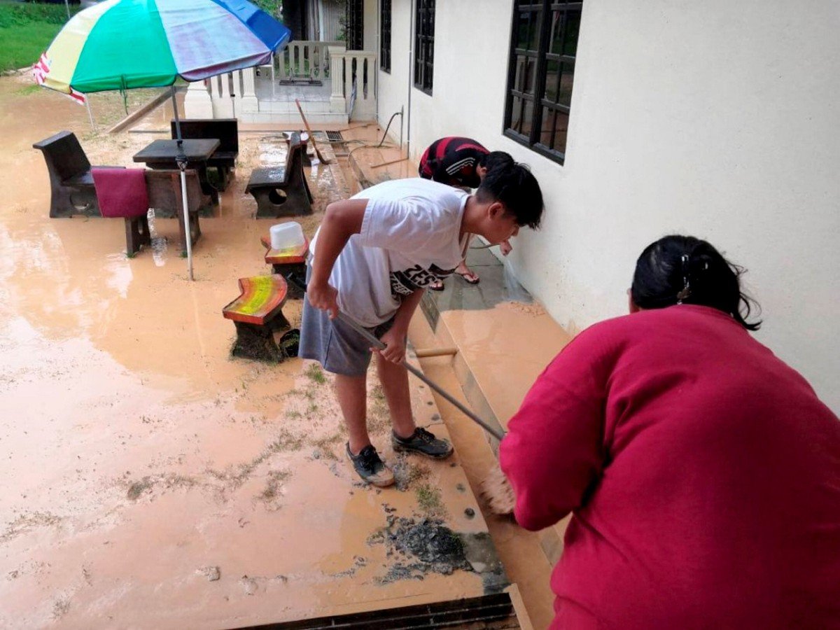 Penduduk Kampung Batu 5 Bangi, Semenyih membersihkan kawasan rumah yang dilanda banjir kilat. FOTO IHSAN PENDUDUK