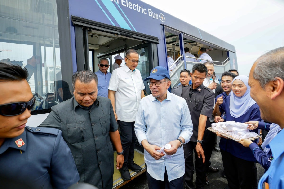 Anwar Ibrahim (tengah) menaiki bas meninjau ladang solar pada Majlis Pelancaran Loji Janakuasa Solar Hibrid Cypark di Cypark Solar Merchang, di sini hari ini. Turut sama Dr Ahmad Samsuri Mokhtar. FOTO BERNAMA