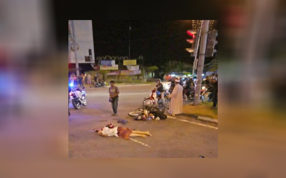 Orang ramai melihat mangsa yang terbaring di jalan raya. FOTO ihsan pembaca