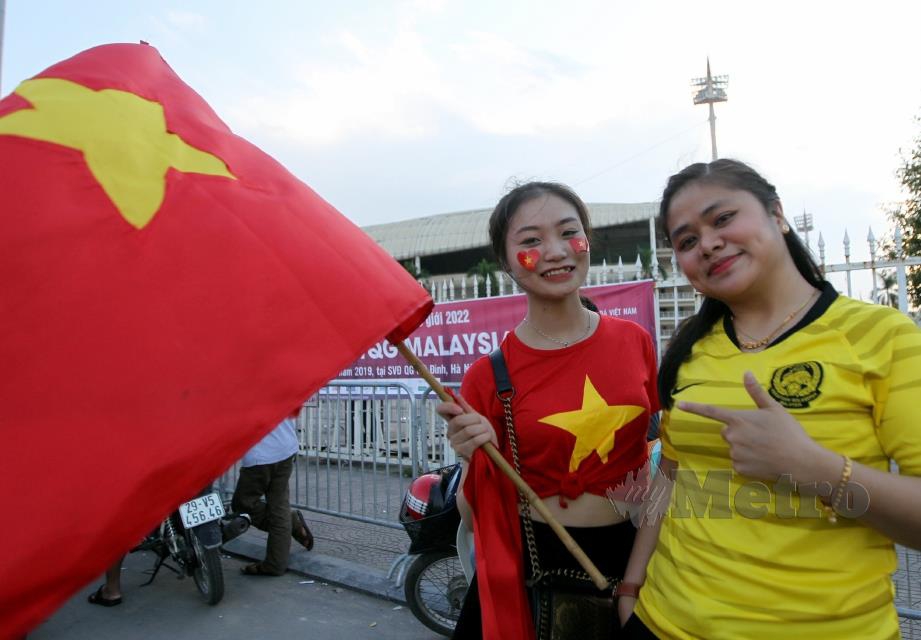 PENYOKONG Vietnam, Seu Teek (kiri) bergambar bersama penyokong pasukan negara, Nur Idayu Hassan di luar Stadium  My Dinh.