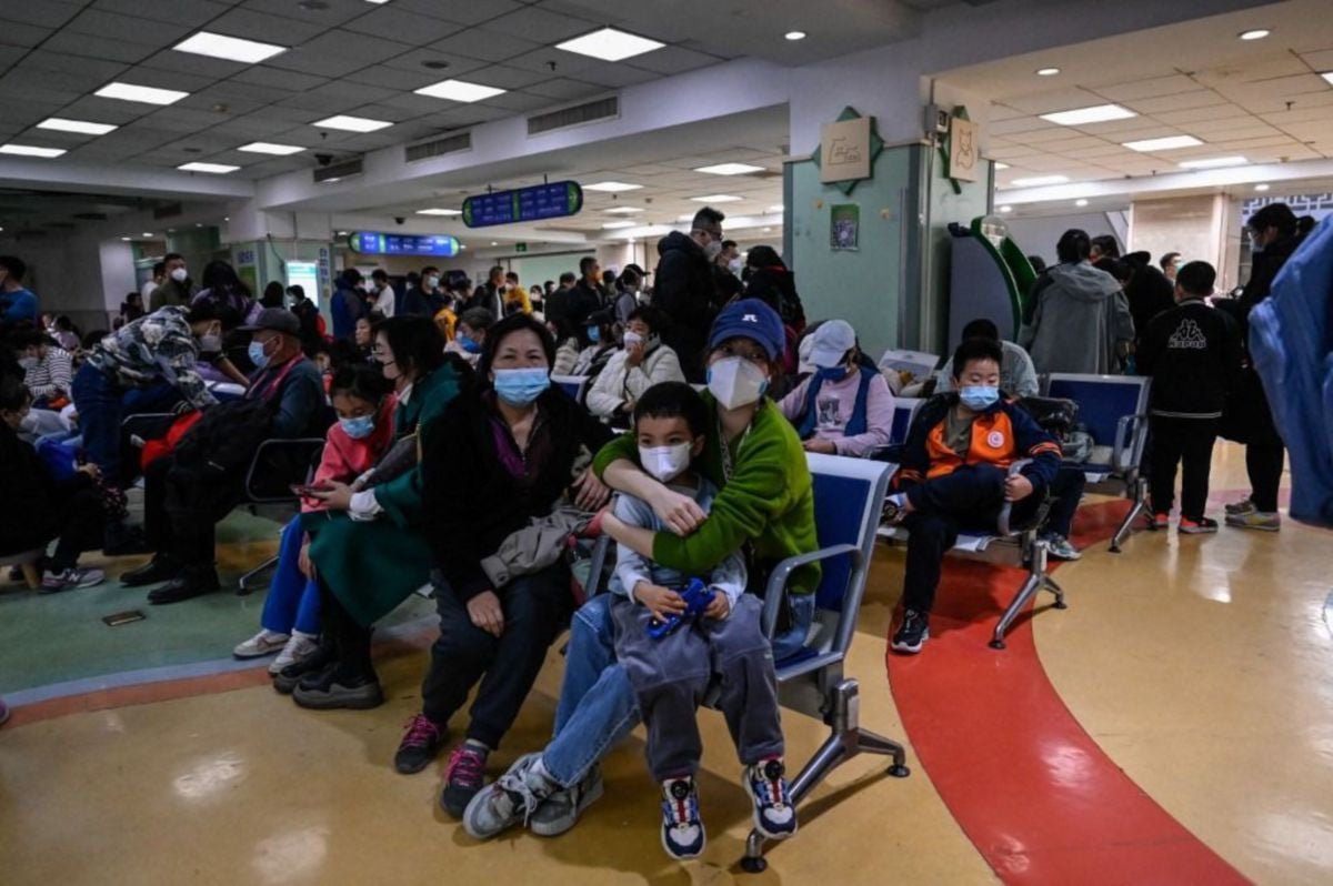 IBU bapa dan anak-anak menunggu di bahagian pesakit luar di sebuah hospital kanak-kanak di Beijing pada 23 November susulan peningkatakan penyakit 'influenza-like illness' . FOTO AFP