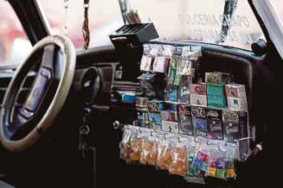 SEORANG pemandu teksi turut menjual rokok dan gula-gula untuk pelanggannya.