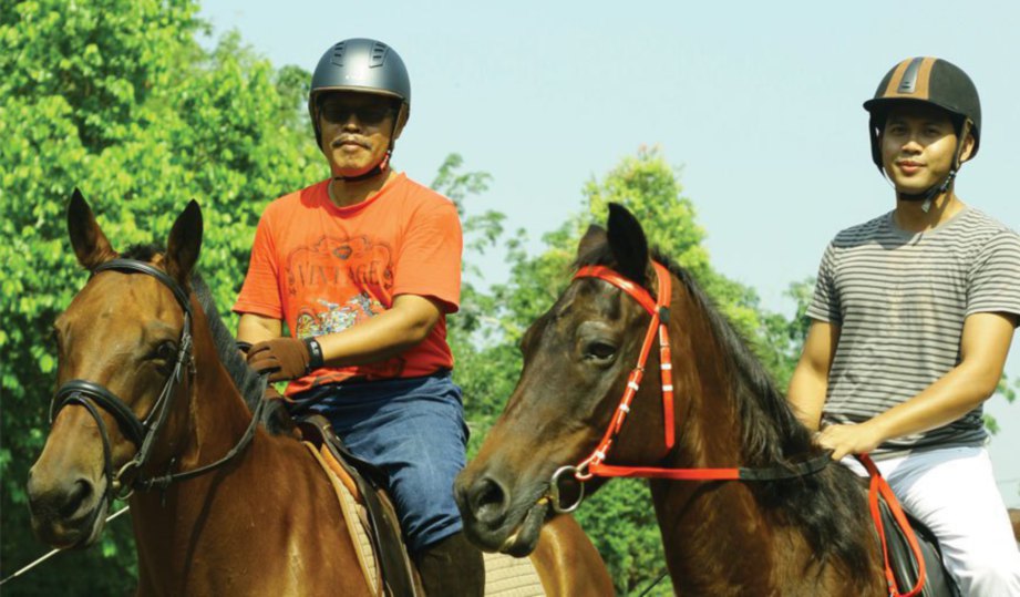 USAMAH (kiri) dan ayahnya beriadah dengan menunggang kuda pada waktu petang.