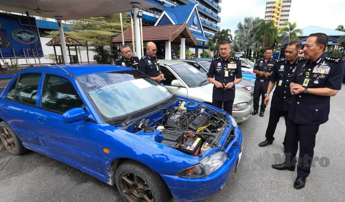 ZAKI (kanan) bersama pegawainya melihat lima kereta Proton Wira yang disyaki dicuri selepas menahan tujuh lelaki dalam serbuan di Kampung Machang Limbat dan Kampung Berhala Lima, Pasir Tumboh di perkarangan IPK Kelantan. FOTO Nik Abdullah Nik Omar