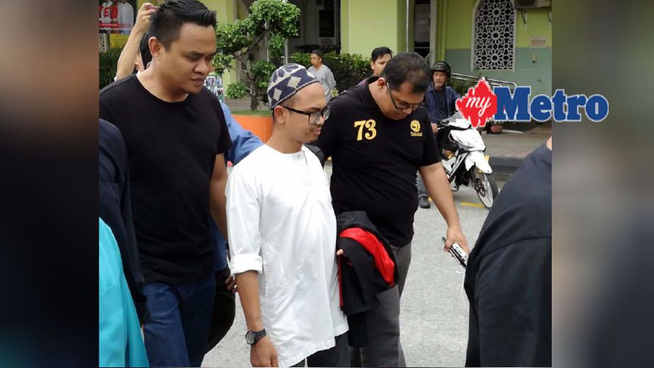 Wan Ji ditahan oleh anggota polis di luar Masjid Sembilang, Seberang Jaya.