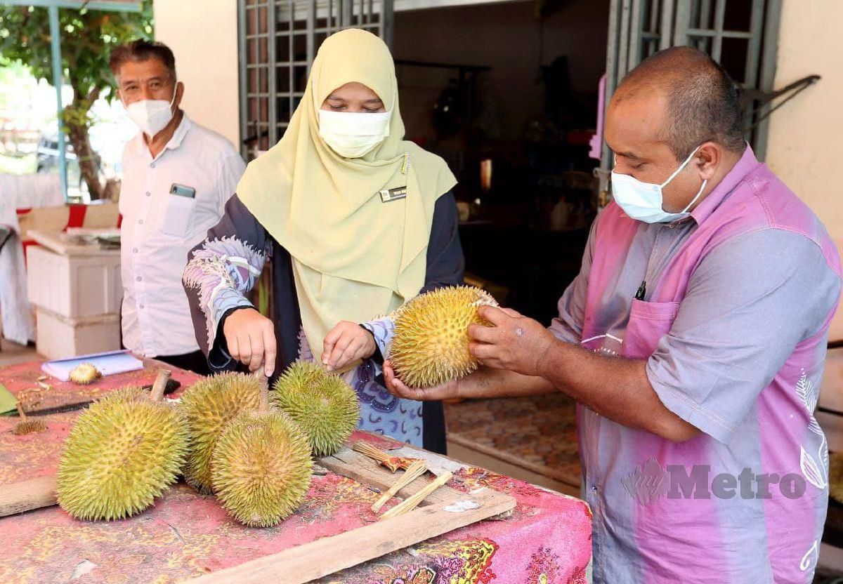Wan Nora (tengah) ketika meninjau gerai jualan durian di Kota Bharu. FOTO NIK ABDULLAH NIK OMAR
