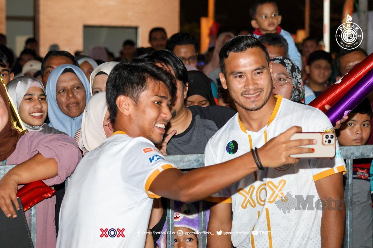 PEMAIN Perak FC, Wan Zack Haikal (kanan) dan Firdaus Saiyadi bergambar dengan peminat ketika majlis pelancaran Jersi Pra-Musim Perak FC 2024, baru-baru ini. FOTO FB PERAK FC 