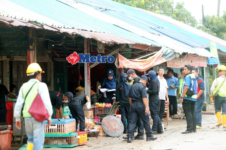 Anggota penguat kuasa PBT Pengerang menyita barangan perniagaan yang dijalankan peniaga warga asing di Kampung Sungai Kapal, Pengerang. FOTO Zulkarnain Ahmad Tajuddin