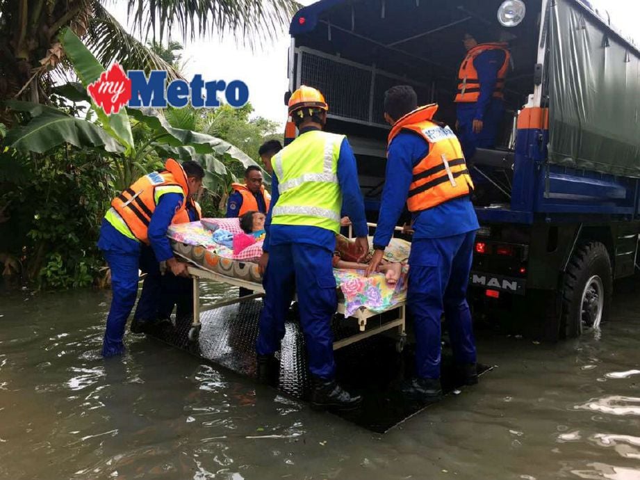 Warga emas diselamatkan APM dalam kejadian banjir kilat di Kampung Pasir. FOTO ihsan JPBD