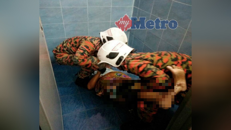 ANGGOTA bomba mengangkat wanita yang terperangkap di dalam bilik air di rumahnya di Taman Bukit Chedang Fasa 2, Seremban, hari ini. FOTO Ihsan JBPM
