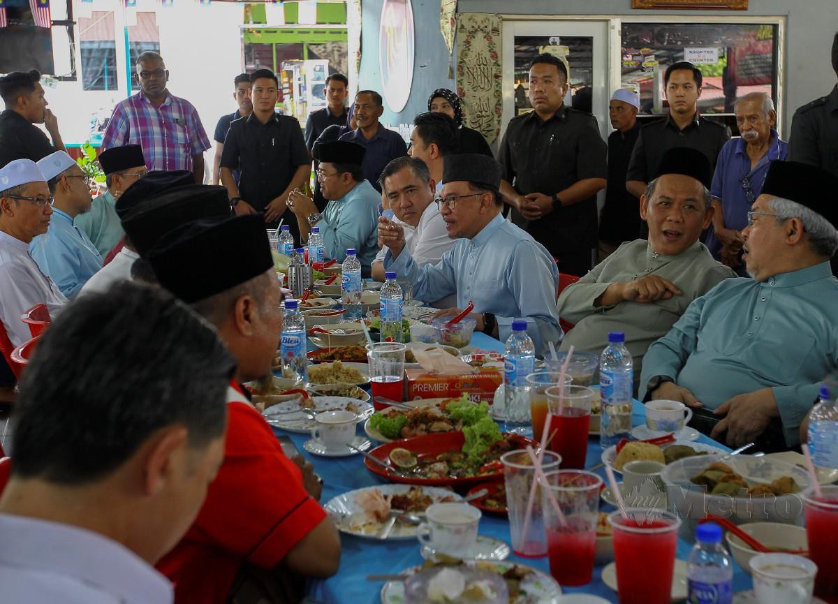Anwar Ibrahim (tiga dari kanan) ditemani Aminuddin (dua dari kanan) ketika makan tengah hari di Kedai Nasi Ayam Hainan Kak Lina di Taman Panchor Jaya. FOTO AZRUL EDHAM 