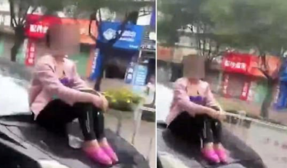 Petikan rakaman video wanita duduk di atas bonet kereta dipandu suaminya. - Foto You Tube