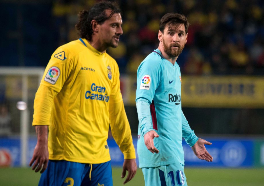 PENYERANG Barca, Lionel Messi (kanan) berkata sesuatu kepada pemain Las Palmas, Matias Aguirregaray selepas kedua-dua pasukan terikat 1-1, awal pagi tadi. - Foto AFP