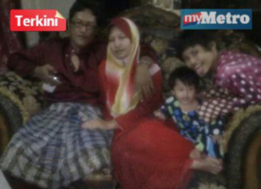Nurhikmah Mohd Zuki, 30, bersama arwah suaminya, Zamani Zakaria, 34, yang maut ketika menyertai konvoi misi bantuan mangsa banjir di Kelantan, Sabtu lalu serta dua anaknya.