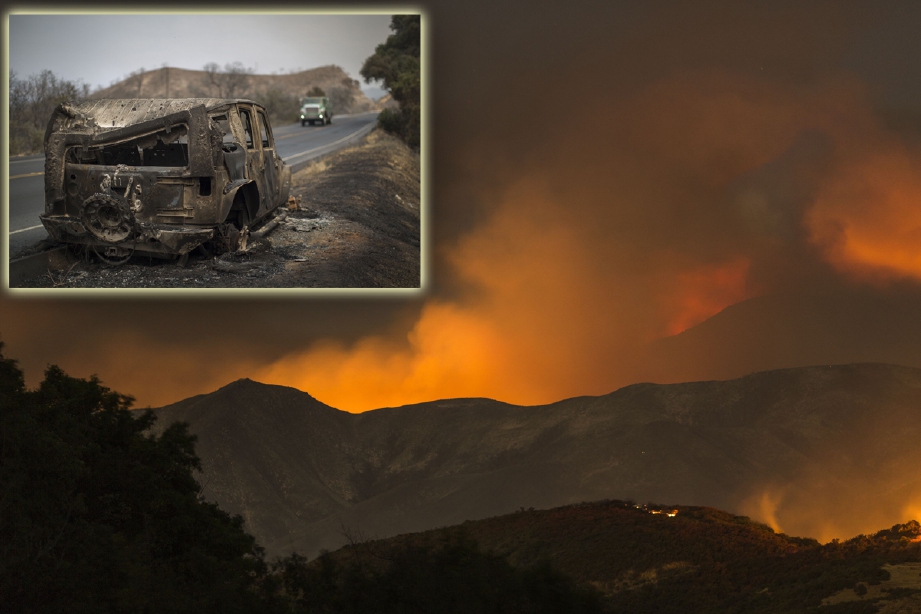 Firefighters pass a Kereta yang musnah akibat kebakaran hutan di Santa Barbara, California. - Foto AFP