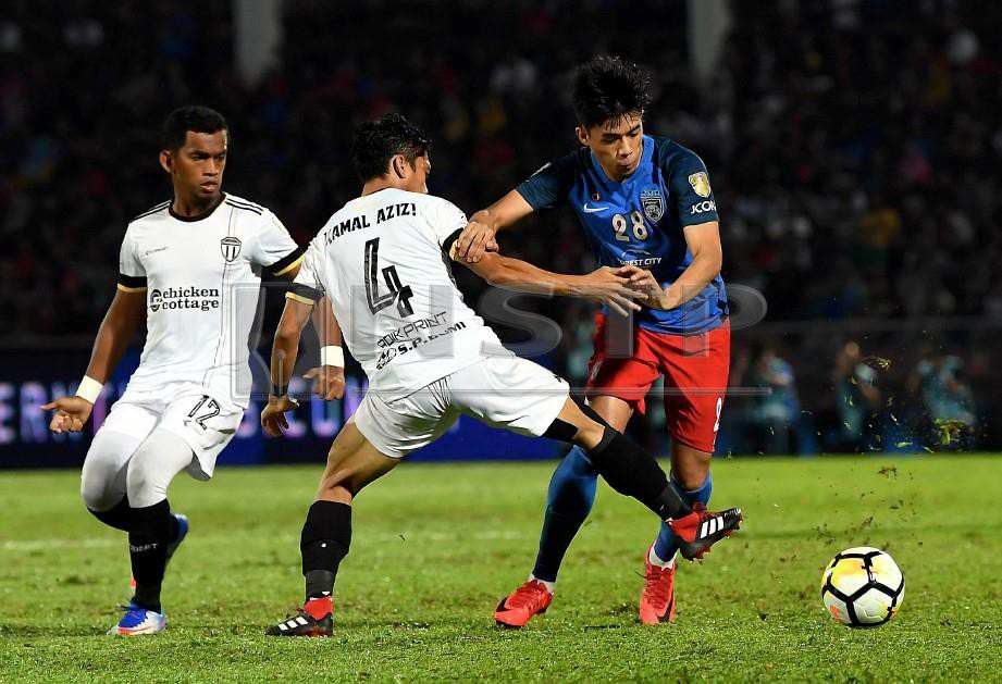 PEMAIN JDT Syafiq Ahmad (kanan) mengelecek pemain TFC Mohd Kamal Azizi (tengah) pada Perlawanan Separuh Akhir Kedua Piala Malaysia di Stadium Tan Sri Hassan Yunos Larkin. -Foto BERNAMA