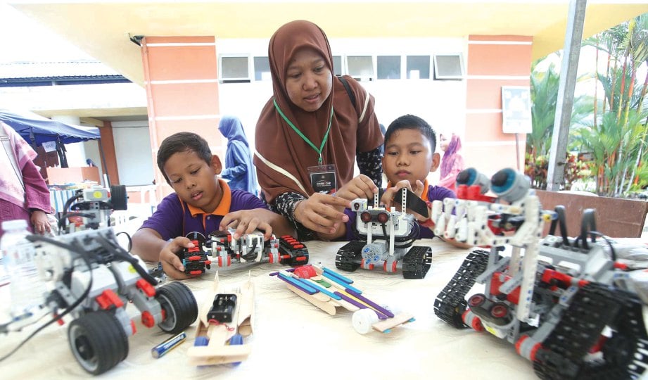 DUA pelajar sekolah rendah ini tekun menyiapkan robotik ketika Jelajah Pendidikan KPM 2018.