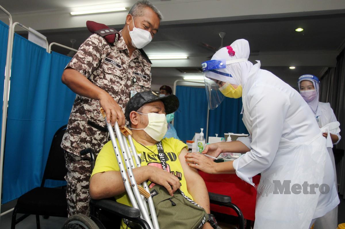 Mohd Faiza Fauzi, 43, yang juga OKU menerima suntikan vaksin Covid-19 di PPV sementara di Penjara Pengkalan Chepa, Kota Bharu pada 16 Jun lalu. FOTO Nik Abdullah Nik Omar.