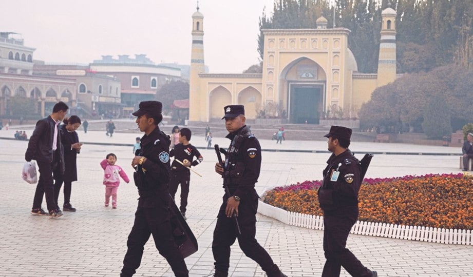 ANGGOTA polis dilihat berkawal di sebuah bandar di Xinjiang.