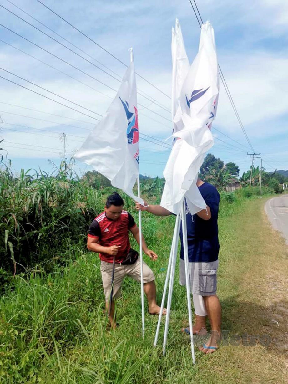 Villorry dan Ryner memasang bendera WARISAN di Kampung Langsat, Kimanis. 