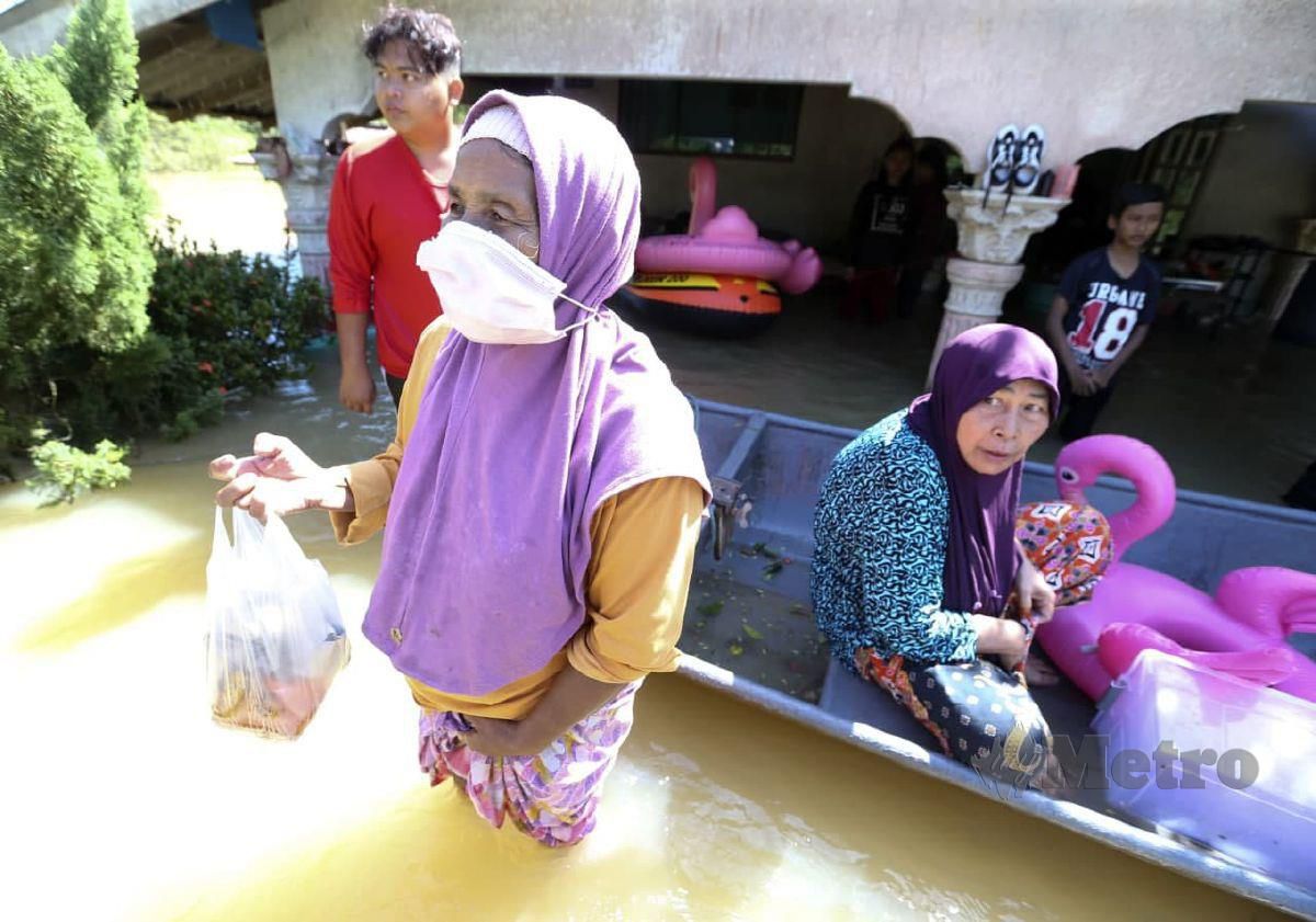 Yah Umat terpaksa berpindah susulan paras air terlalu tinggi  dan deras sehingga menenggelami rumahnya di Kampung Tersang. FOTO NIK ABDULLAH NIK OMAR