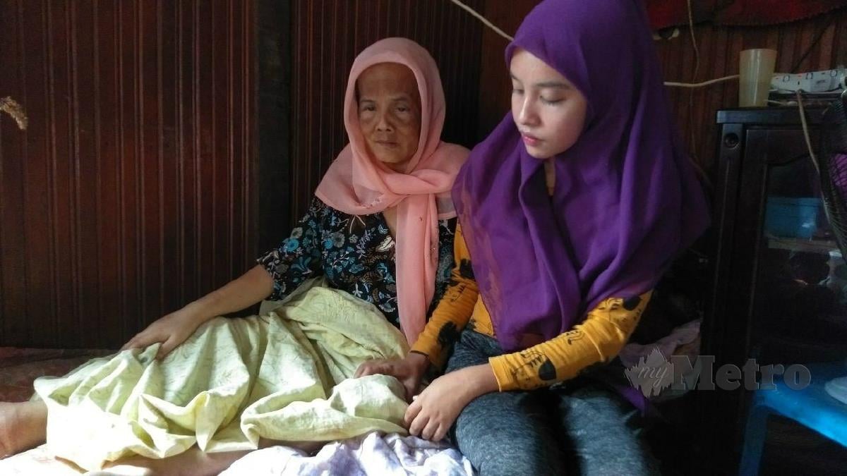 WAN Nurul Safikah mengurut Mek Yah yang terlantar akibat pelbagai penyakit di Kampung Pangkal Changgong, Machang, semalam. FOTO SITI ROHANA IDRIS
