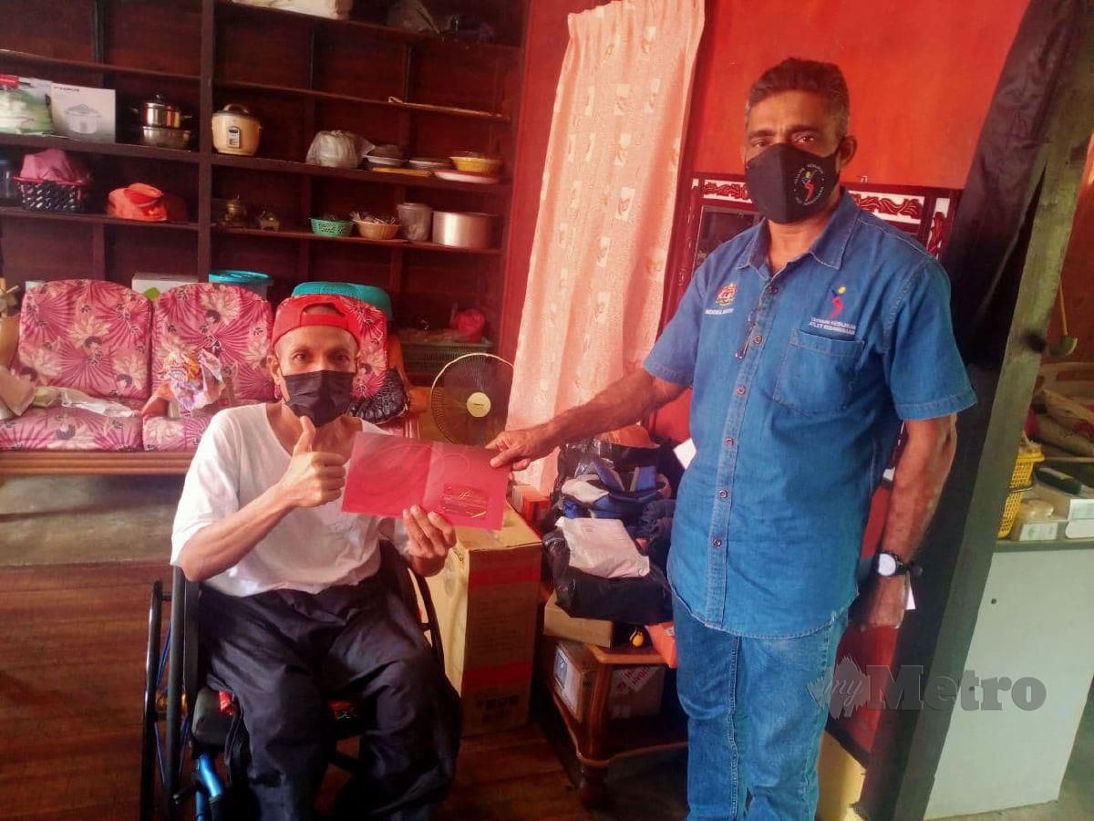 Abdul Halim menerima sumbangan daripada Noorul Ariffin yang datang ke rumahnya di Kampung Linggi, Port Dickson. FOTO MOHD KHIDIR ZAKARIA