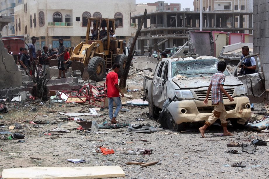 Pasukan keselamatan memeriksa kawasan serangan bom kereta di Aden, Yaman, hari ini. - Foto AFP 