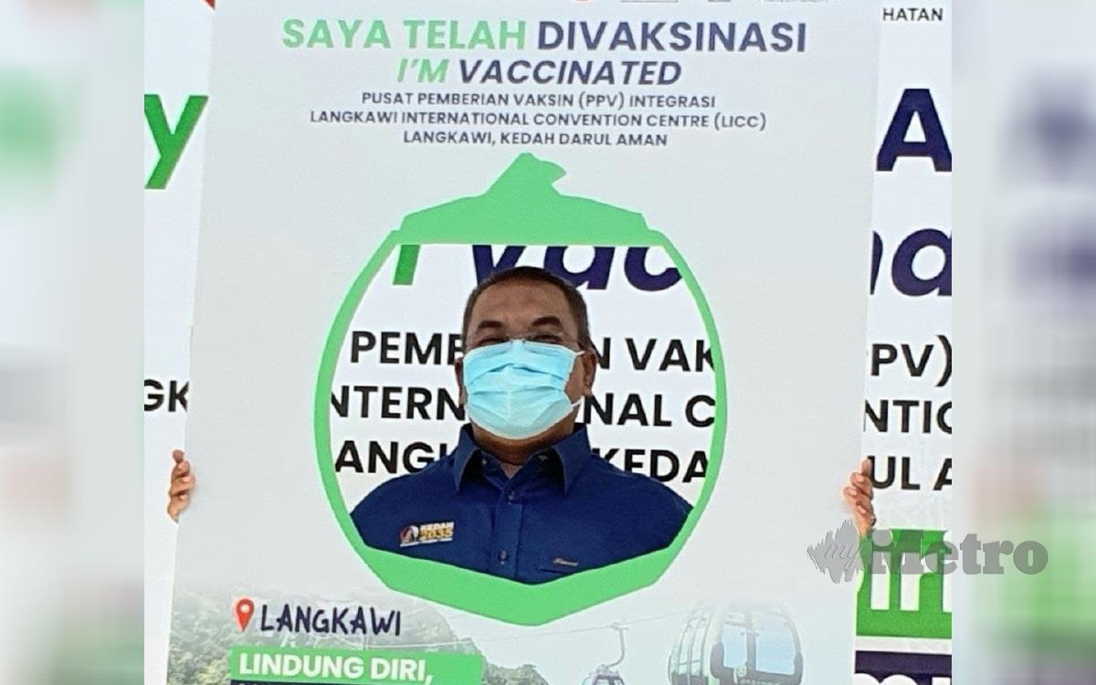 Muhammad Sanusi bergambar bersama plakad 'Saya Telah Divaksin' ketika melakukan Lawatan Kerja ke Pusat Pemberian Vaksinasi (PPV) Integrasi di Pusat Konvensyen Antarabangsa Langkawi (LICC), Langkawi. FOTO HAMZAH OSMAN