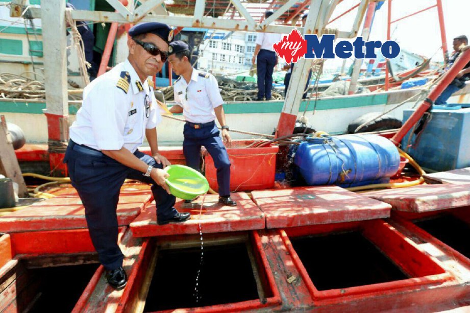 Pengarah APMM Terengganu Kapten Zainolabidin Jusoh menunjukkan diesel yang ditemui dalam bot nelayan yang ditahan. FOTO Aswadi Alias