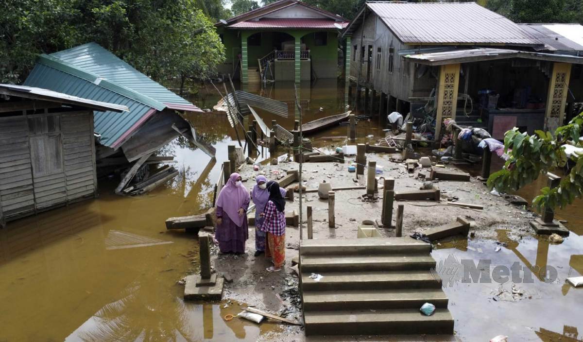 SITI Zailah meninjau salah sebuah rumah Muhammad Rodi Zakaria yang dihanyutkan arus banjir ketika ditemui selepas membuat lawatan mangsa banjir di Kampung Tersang. FOTO Nik Abdullah Nik Omar