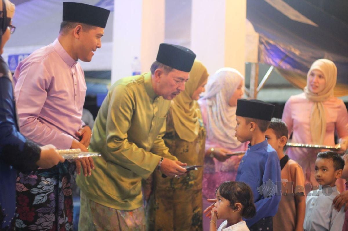 Muhamad Zaki (dua dari kiri) ketika menyampaikan duit raya kepada kanak-kanak sempena Sambutan Hari Raya Aidilfitri Peringkat Ibu Pejabat Polis Daerah (IPD) Bachok bagi Tahun 2024/1445H di Balai Polis Jelawat, Bachok. FOTO Nor Amalina Alias 