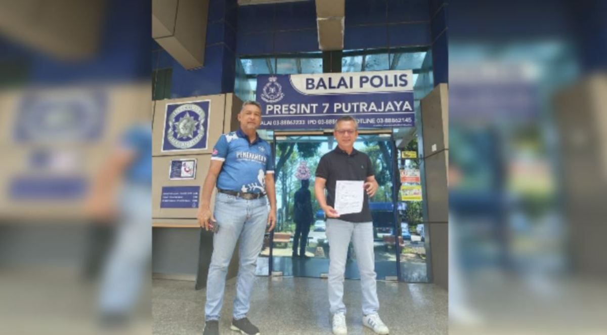 RAZALI (kanan) menunjukkan laporan polis yang dibuat di Balai Polis Presint 7, Putrajaya. FOTO Ihsan pembaca.