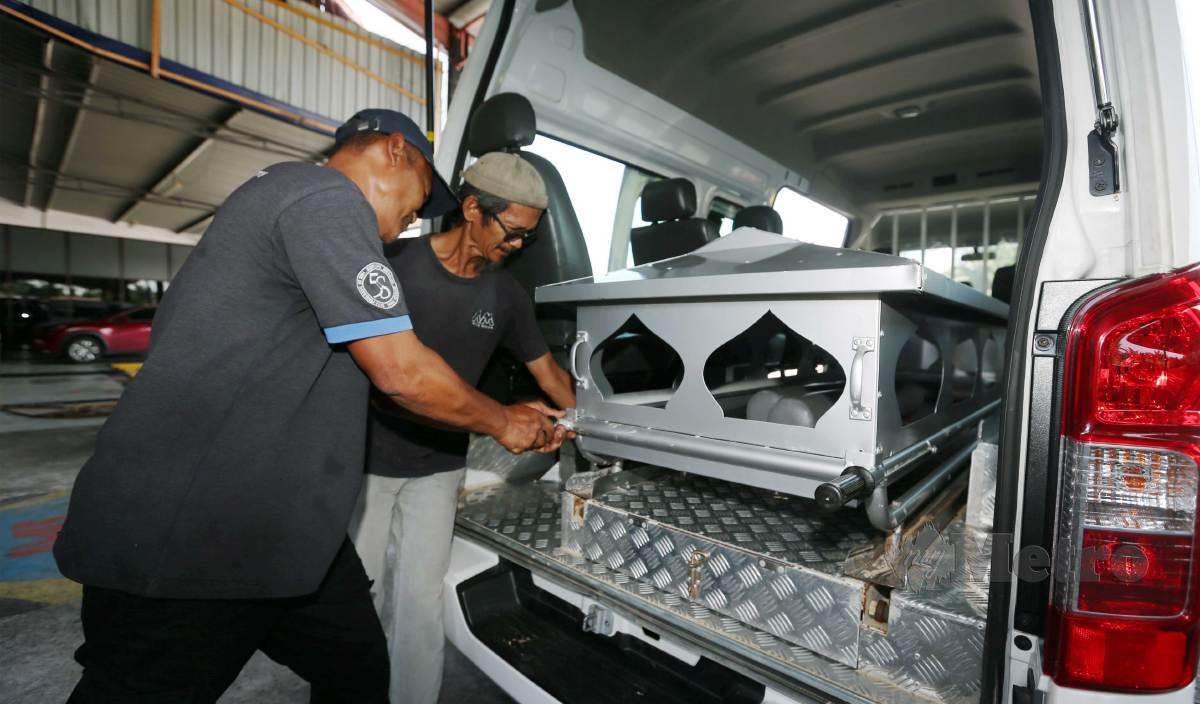 MASDAR bersama rakannya Nizam membuat baik pulih van jenazah di Azam Motor, Banting. FOTO Rohanis Shukri