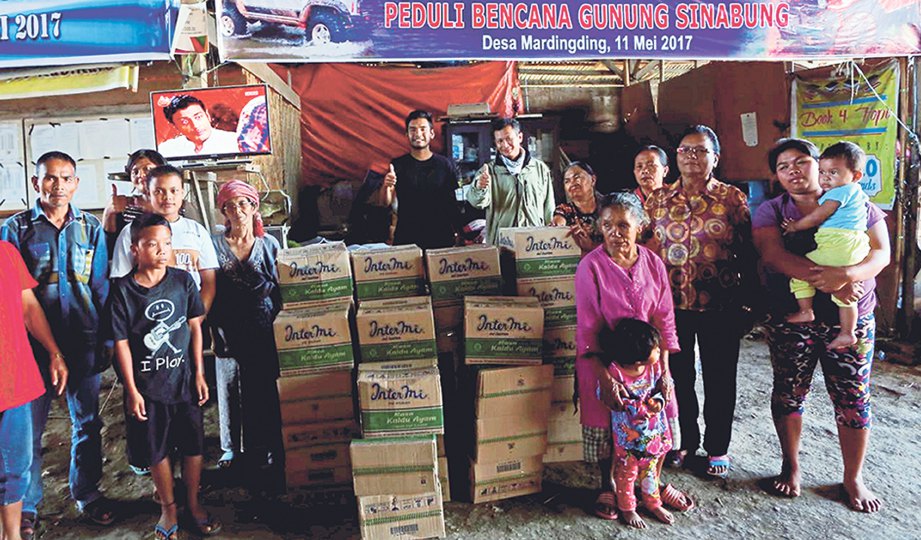 BERSAMA sukarelawan memberikan bantuan kepada mangsa bencana Gunung Berapi Sinabung, Indonesia.