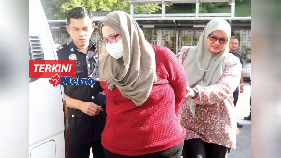 Pengasas Zurin Jundi Wedding Planner, Zurina Ahmad Jundi diiringi polis ketika dihadapkan ke mahkamah atas tuduhan menipu pelanggan di Mahkamah Sesyen Johor Bahru. FOTO Hairul Anuar Rahim 